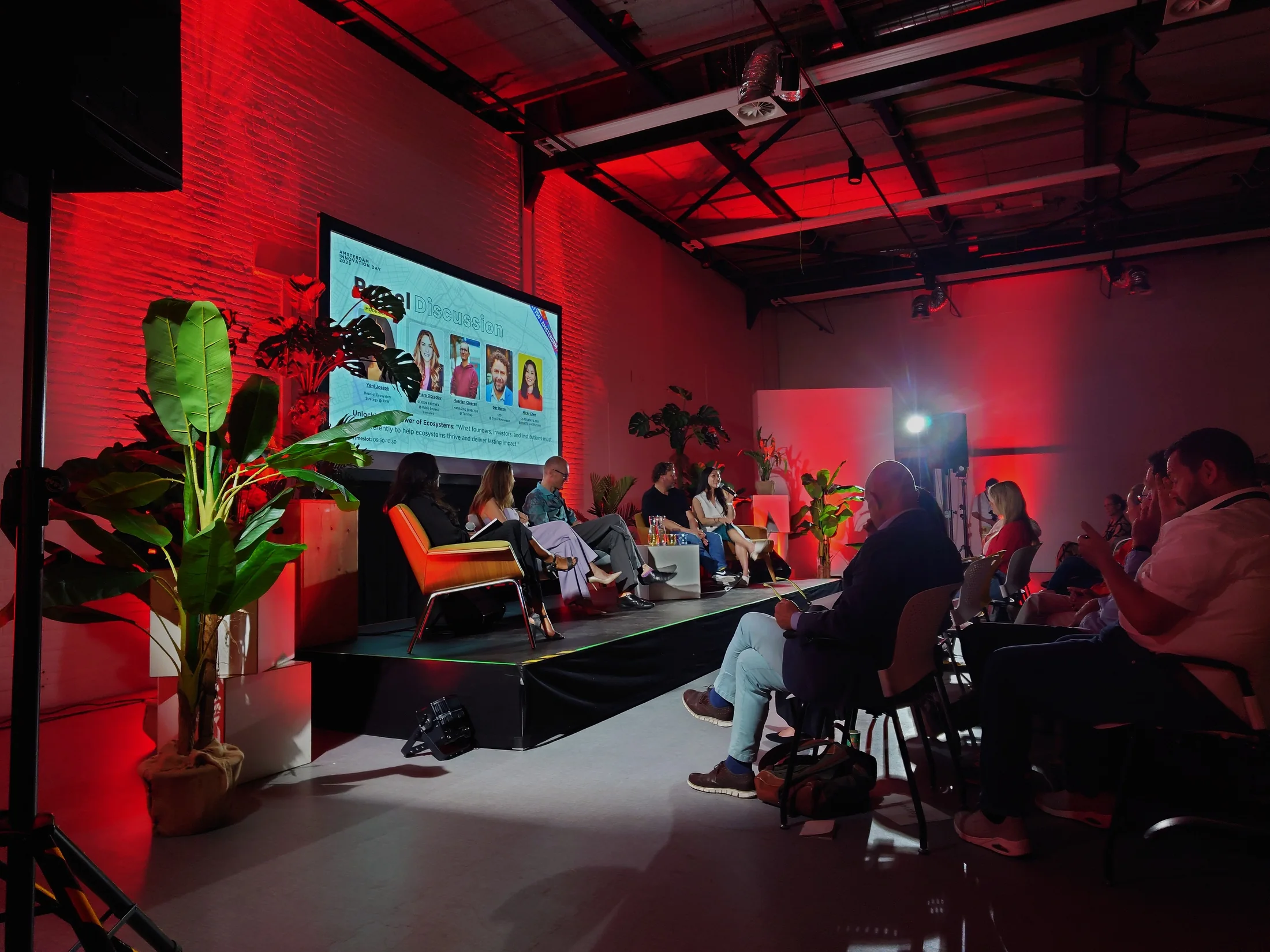 Podiumtechniek, audio en rode sfeerverlichting tijdens Amsterdam Innovation Day 2025