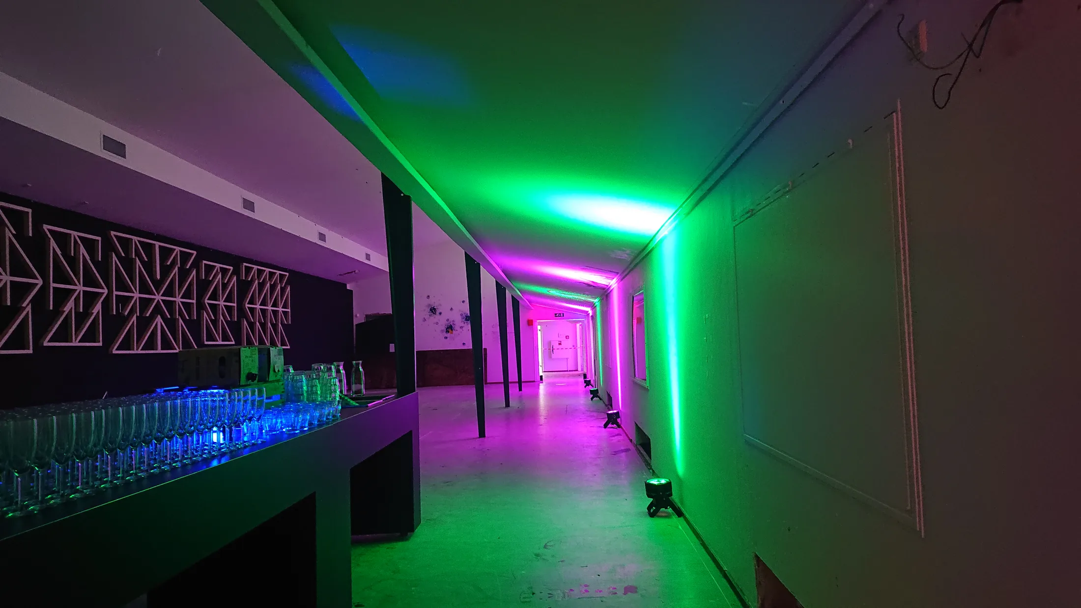 Groene en roze accu-uplights langs een looproute in Museum Arnhem